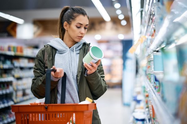 Young,Woman,Buying,Diary,Product,And,Reading,Food,Label,In